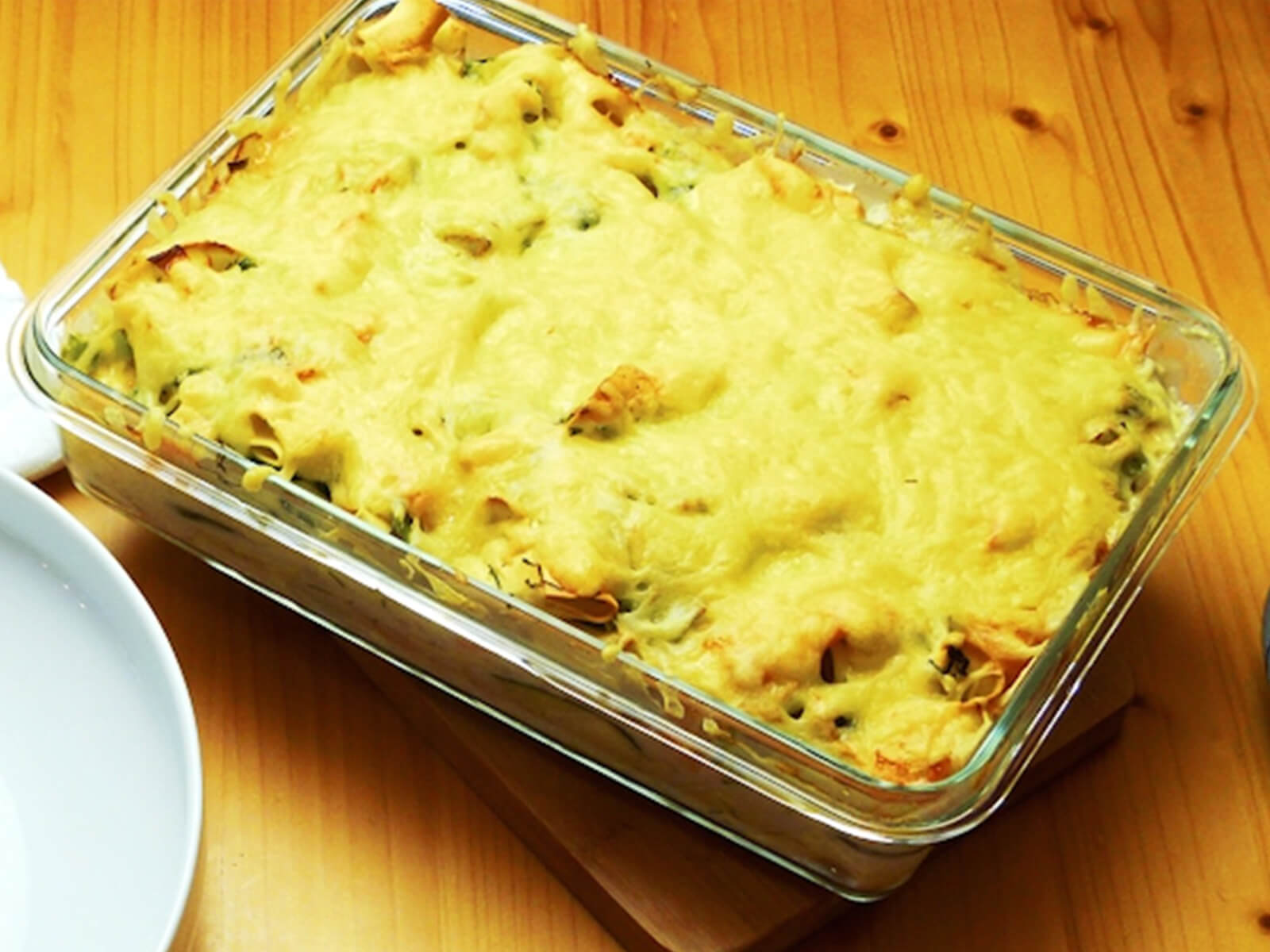 Nudelrezept von Tress: Ofenform aus Glas gefüllt mit Nudeln, Räucherlachs, Zucchini und mit Käse überbacken