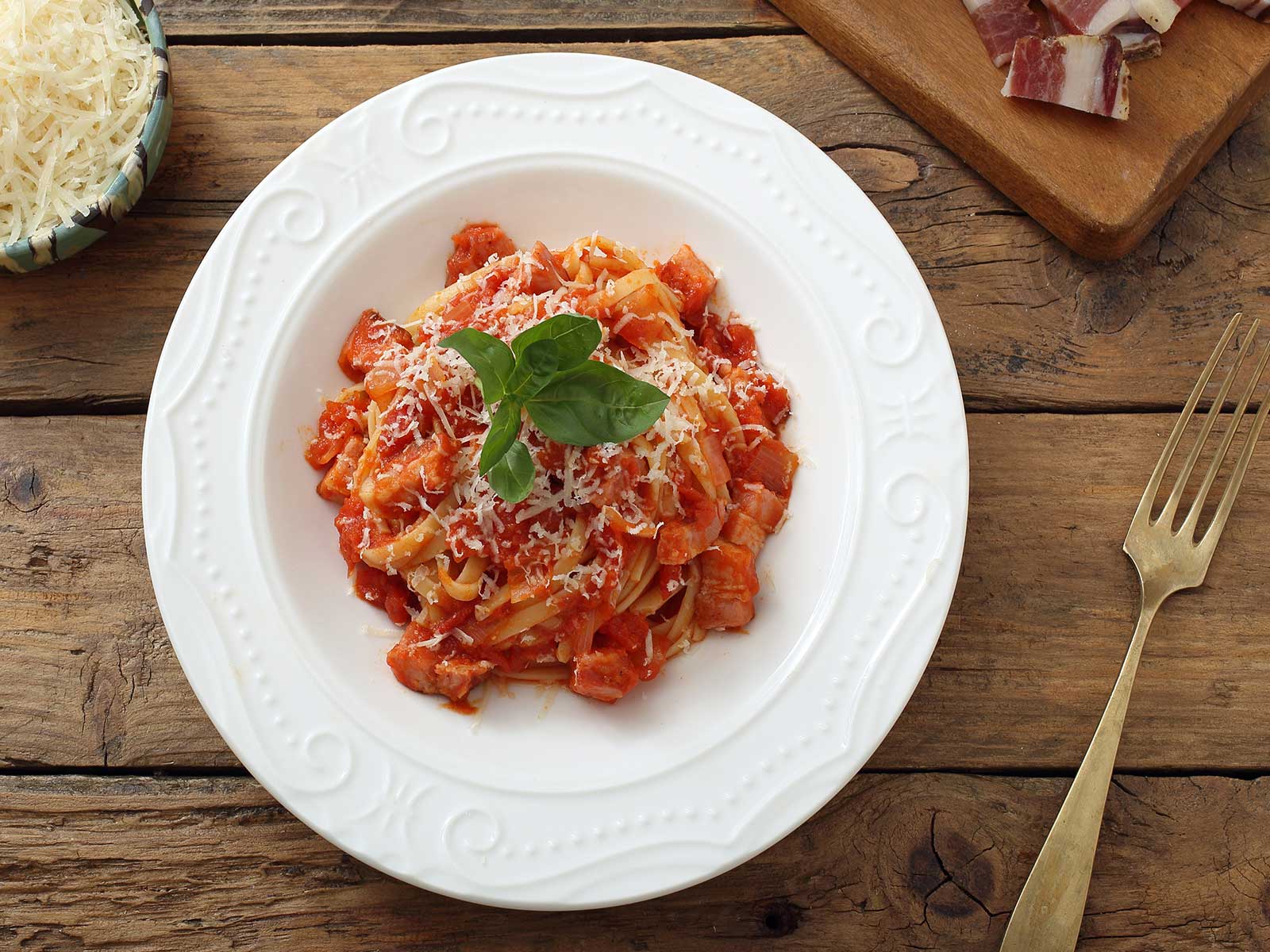 Nudelrezept von Tress: ein Teller mit Bandnudeln, Tomatensoße und Speck