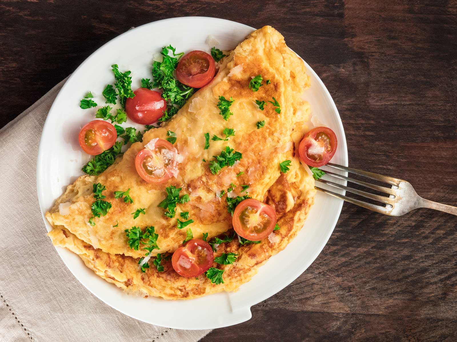 Omelette mit frischer Petersilie, halbierten roten Kirschtomaten nach einem Rezept von Tress