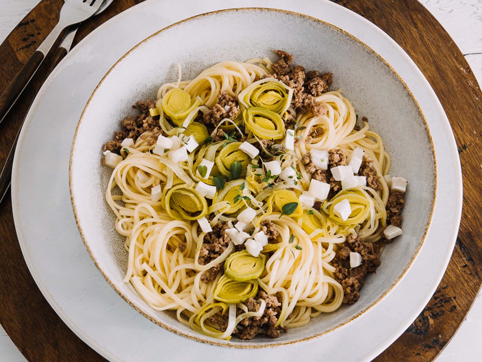 Spaghetti-Gericht von Tress mit Hackfleisch und Lauch angerichtet auf einem weißen Teller